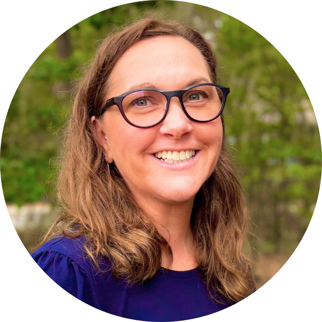 A woman (Laura Pierce, Operations Manager) smiling. She has light brown, shoulder-length hair, glasses, and a navy blue blouse.