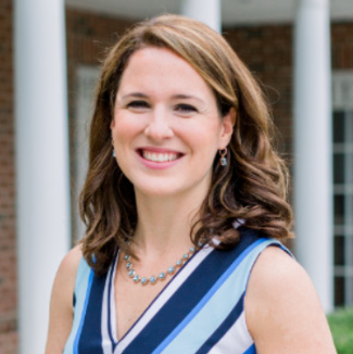 Image of Sarah TeDesco, DonorSearch COO. Sarah has wavy, shoulder-length auburn hair, earrings,and is smiling. She's wearing a multi-colored blue striped dress.